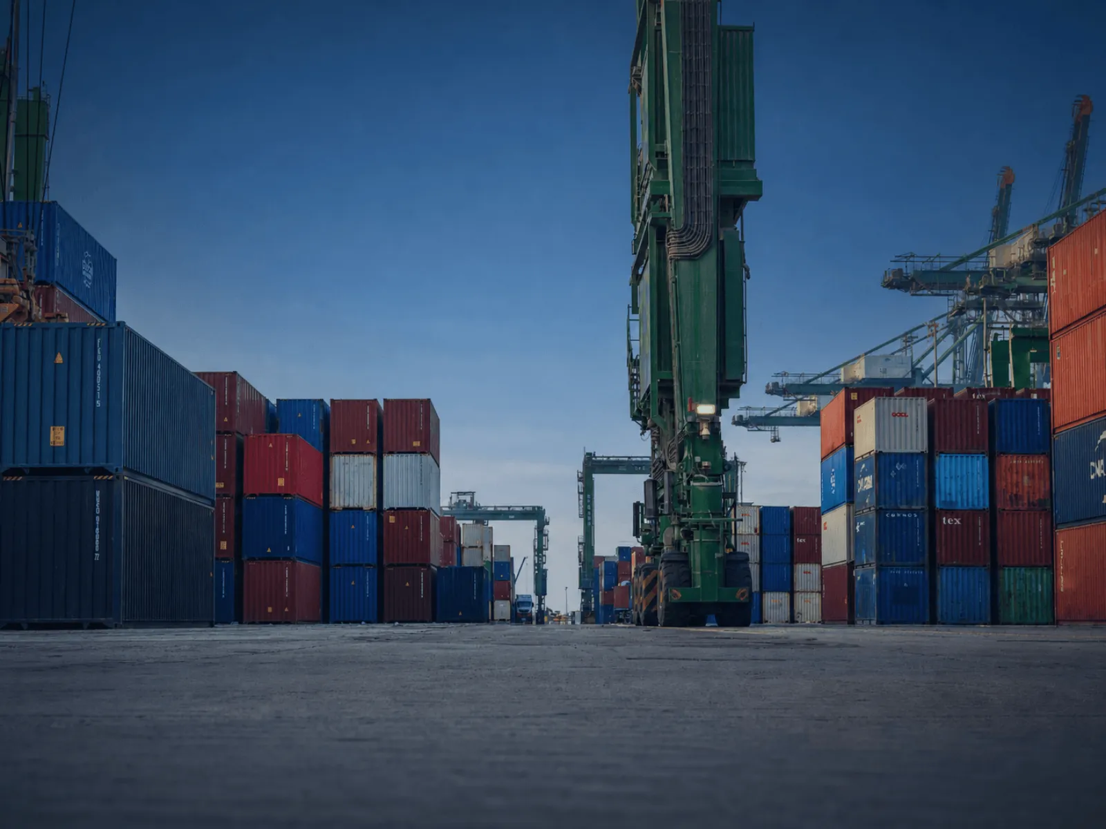 Container yard with stacked shipping containers and heavy port equipment